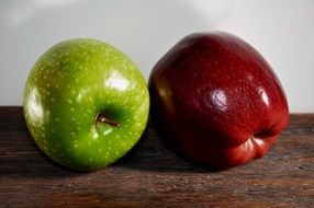 red and green apple on a wooden table