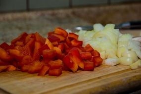 chopped parkika and onions on a kitchen board