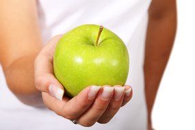 girl holding a green apple