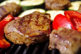 grilled meat with tomatoes and zucchini close-up