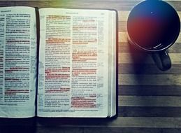 bible on the table next to a cup of coffee