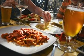 pasta on white plate glass of beer