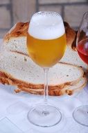 glass of beer on a background of bread
