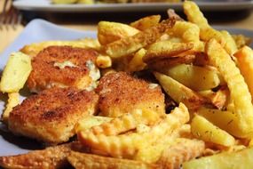 fried potatoes with meatballs on a white plate