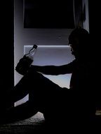 silhouette of a lonely drinking man