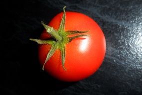 red shiny tomato on black surface