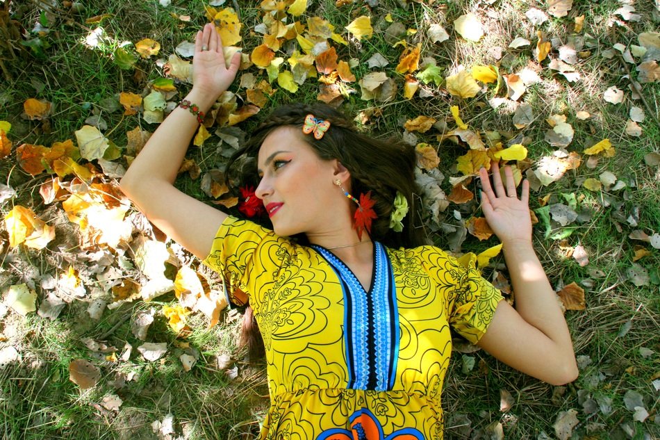 girl in colorful clothing on a background of of autumn leaves
