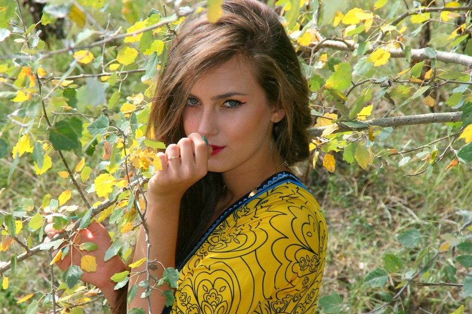 girl with a beautiful look of the background of the autumn branches