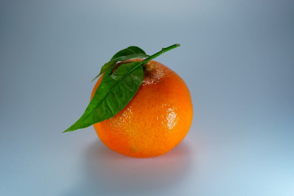 orange with leaves on white table