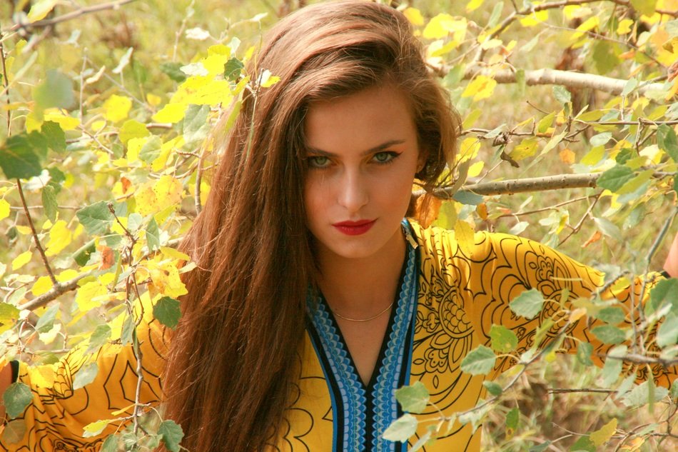 girl with a long hair of the background of the autumn branches