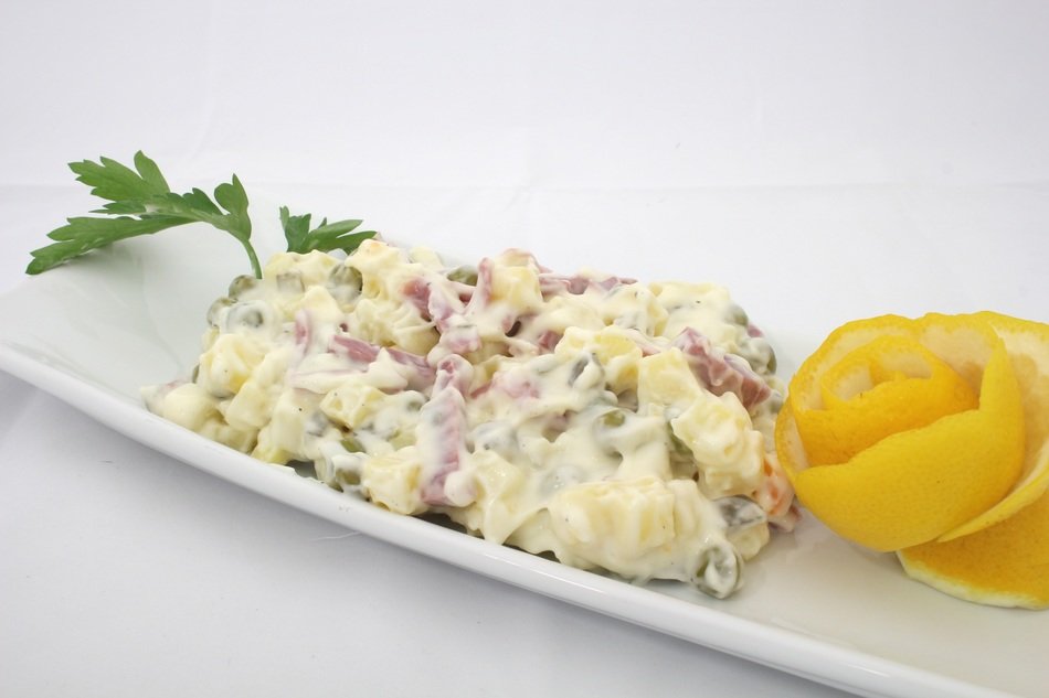 italian salad with mayonnaise and orange decoration on the plate