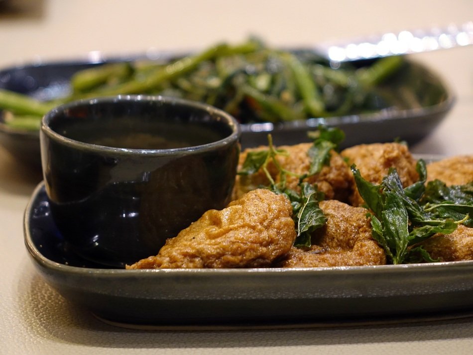 Panasian cuisine: the plate with fried piece of meat or fish with greens