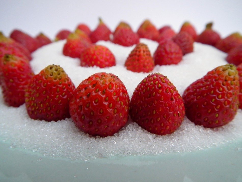 red strawberries on white sugar as a dessert