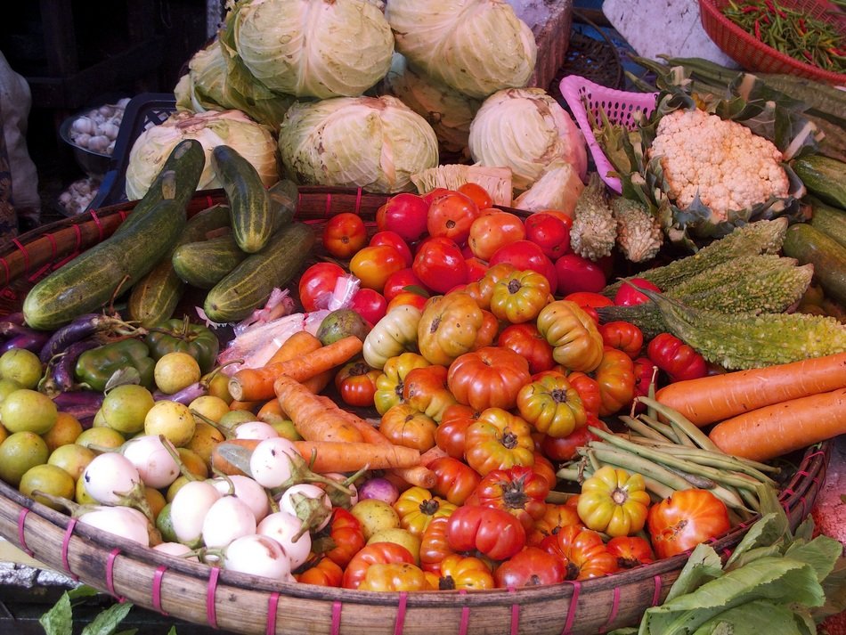 A backet of tomatoes,culiflowers and zucchinies