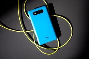 blue Nokia Lumia 820 with yellow wire