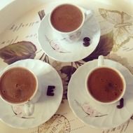 three cups with coffee on tray