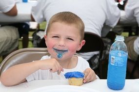 boy eating a cupcake at the table