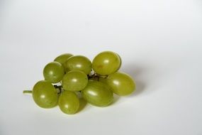 bunch of green grapes on a white surface