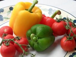 Yellow and green peppers and tomatoes on a plate