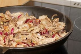 fried meat with onions in a pan