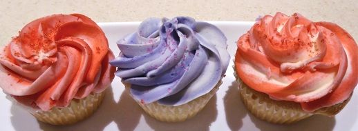 three colorful creamy cupcakes