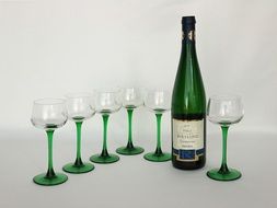 a bottle stands near the glasses