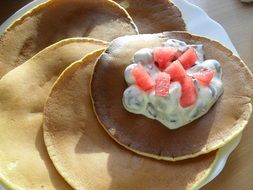 delicious breakfast consisting of pancakes with whipped cream