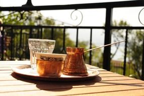 Cup of coffee is on the table on terrace