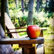 red-yellow apple on a wooden chair on the terrace