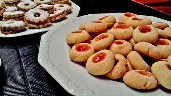 Christmas cookies with jam on white plates