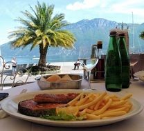 dish and drinks on served table at mountain lake