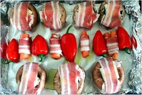 paprika, carrots and mushrooms in bacon on the grill