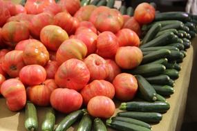 tomatoes and green zucchinis on market stall