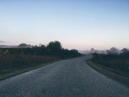 deserted asphalt road in the morning haze