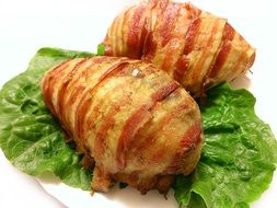 food in bacon on green lettuce leaves