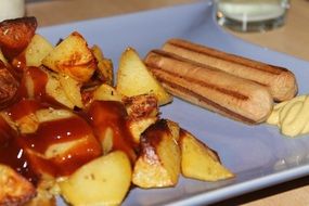 fried potatoes with ketchup and sausages