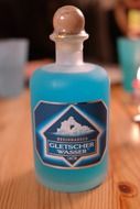 bottle of blue liqueur alcohol glacier water