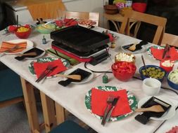 table served for raclette cheese party, nobody