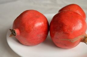 red fresh pomegranate on white plate