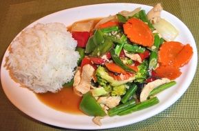 thai chicken with basil on white plate