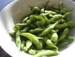 soybeans in green pods in a white plate