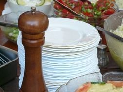 pepper mill and many white plates