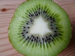 half kiwi lies on a wooden board