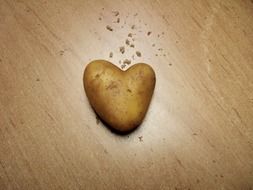 heart shaped potato on a wooden surface