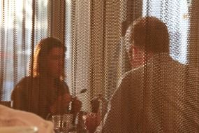 couple in a cafe behind the curtain