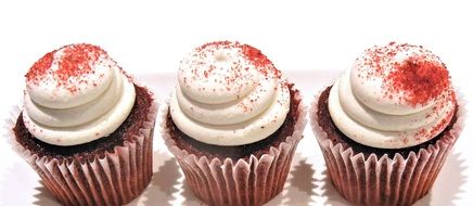 three red velvet cupcakes with white cream