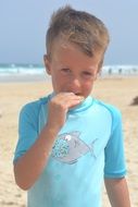 boy in blue bathing suit on the beach