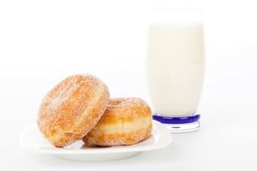 a glass of milk and two donuts