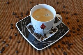a cup of coffee and coffee beans around