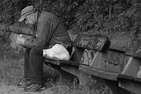 man eats on a bench alone